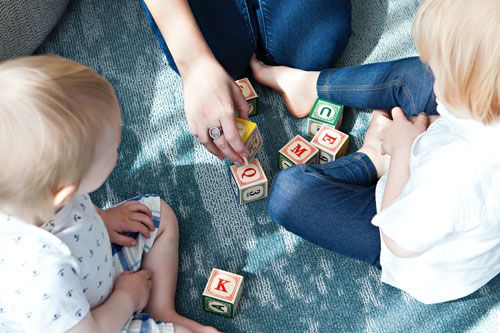 photo de deux jeunes enfants jouant avec des cubes contenant des lettres