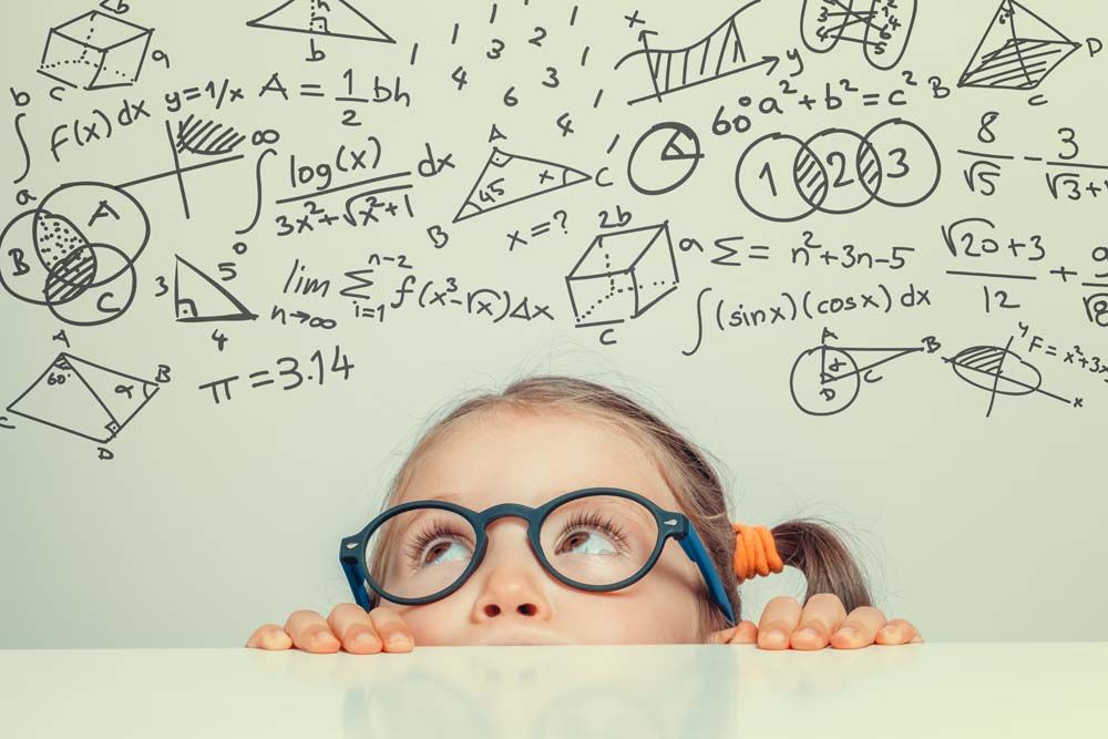 image d'une enfant qui regarde des inscriptions mathématiques au-dessus d'elle