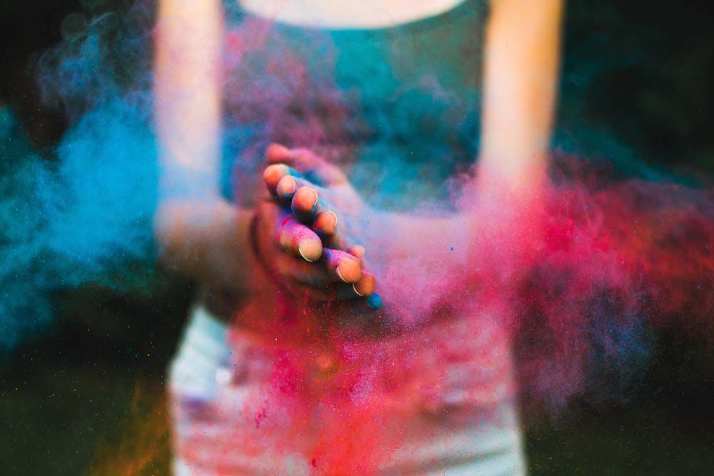 photo de deux mains jointes et dont émanent des couleurs rouge et bleu